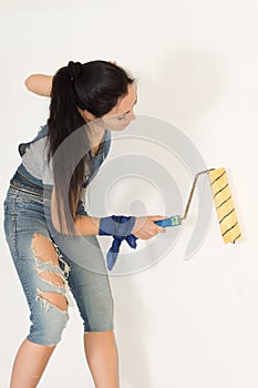 Woman standing painting a wall
