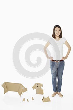 Woman standing with paper animals by her side
