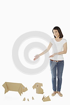 Woman standing with paper animals by her side