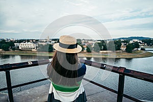 Woman standing on the pier in the city and looking on the river