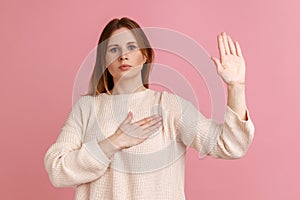 Woman standing with promise hand sign, gesturing palm up, giving promise, pledging allegiance