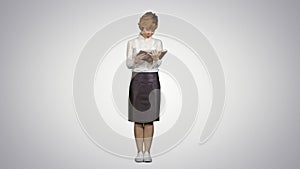 Woman standing and reading book on white background