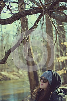 Woman standing on riverbank in woods