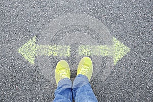 Woman standing on road near arrows marking