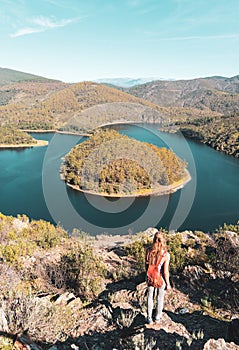 Woman standing on rock looking at meander