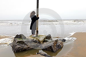 Girl rain sea wind winter portrait woman smile spring coat long hair curly mood shore snow beach autumn deadpan