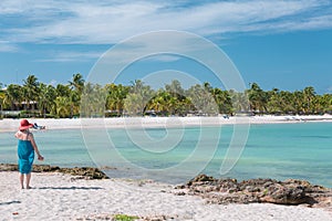 Woman standing on rocky seashore and looking toward