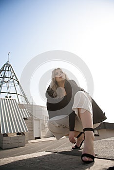 Woman standing at rooftop on a sunny autumn day.