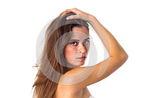 Woman standing sidewise and fixing hair