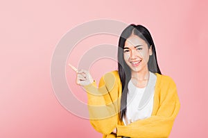 Woman standing smiling indicate finger empty space