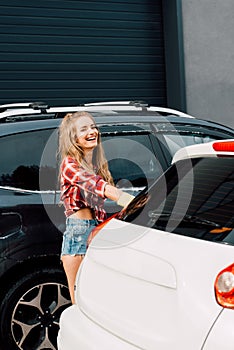 Woman standing and smiling near modern automobiles