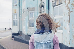 Woman standing in street outside blue house