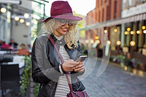 Woman standing on the street and texting photo