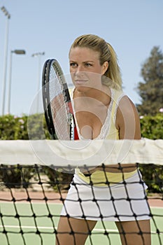 Woman standing at Tennis Net waiting for serve