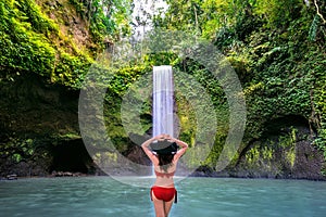 Woman standing in Tibumana waterfall in Bali island, Indonesia. photo