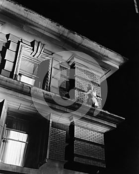 Woman standing on the top of a building on a ledge photo