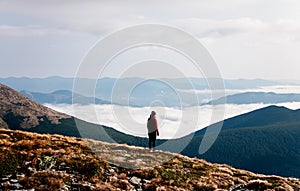 Woman standing at the top of the mountain. Amazing landscape in the mountains.