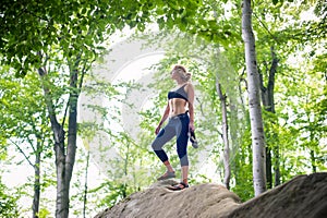 Woman standing on the top of rock after climbing boulder