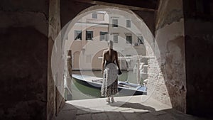 Woman standing under arcades of Chioggia