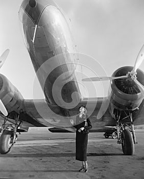 Woman standing under a large aircraft looking up