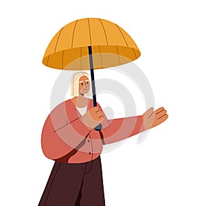 Woman standing under open umbrella, checking with palm if it is rain. Young person holding protecting umbrela in hand in