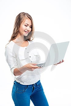 Woman standing and using laptop