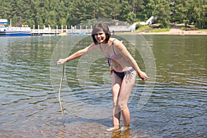 A woman standing water with horror sees black poisonous snake attacking