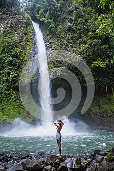 Woman standing by the waterfall