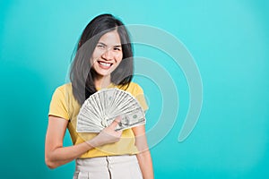 Woman standing wear t-shirt smiling holding money fan banknotes 100 dollar bills