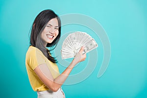 Woman standing wear t-shirt smiling holding money fan banknotes 100 dollar bills
