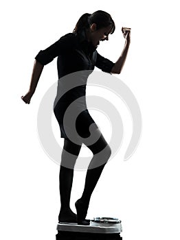 Woman standing on weight scale happy silhouette