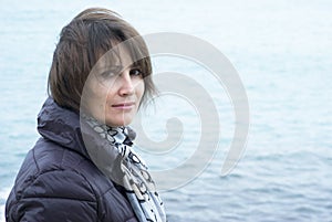 Woman standing in windy conditions in front of the sea