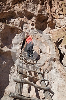 Woman Standing on a Wooden Ladder at Bandelier National Monument