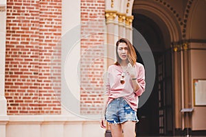 The woman stands beside the church entrance.