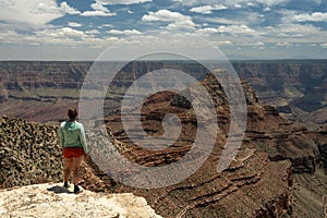 Woman Stands On The Edge And Looks Out Over The North Rim Of Grand Canyon
