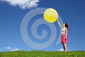 Woman stands on grass and starts inflatable ball