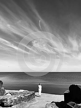 A woman stands and looks over Lake Erie - The Great Lakes - Cleveland, Ohio - USA