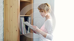 Woman stands next to a shelf with records