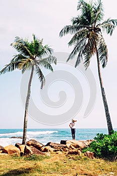 Woman stands at the ocean coast and looks on horizont line