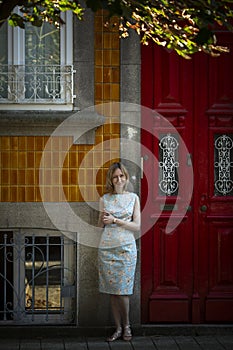 A woman stands outside a traditional Portuguese house in Porto.