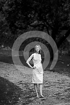 A woman stands on a park path. Black and white photo.