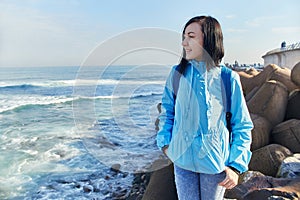 Woman stands on Shore of the Atlantic Ocean, raging waves hitting the shore, the surf. Casablanca, Morocco