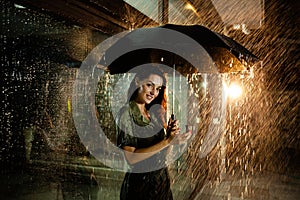 Woman stands under the rain