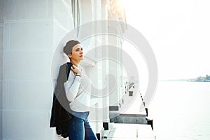 A woman stands on the waterfront of the port