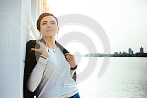 A woman stands on the waterfront of the port