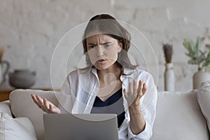 Woman staring at laptop feels angry due to broken device