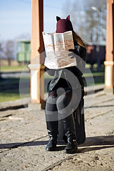 Woman at station hide face behind map