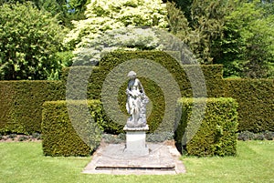 Woman statue. hedges. topiary trees