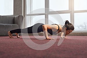 Woman staying four limbet staff pose of yoga.
