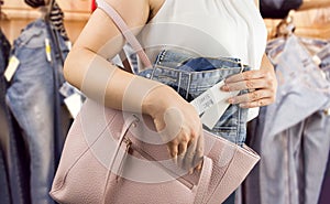 Woman steals trousers at the boutique photo